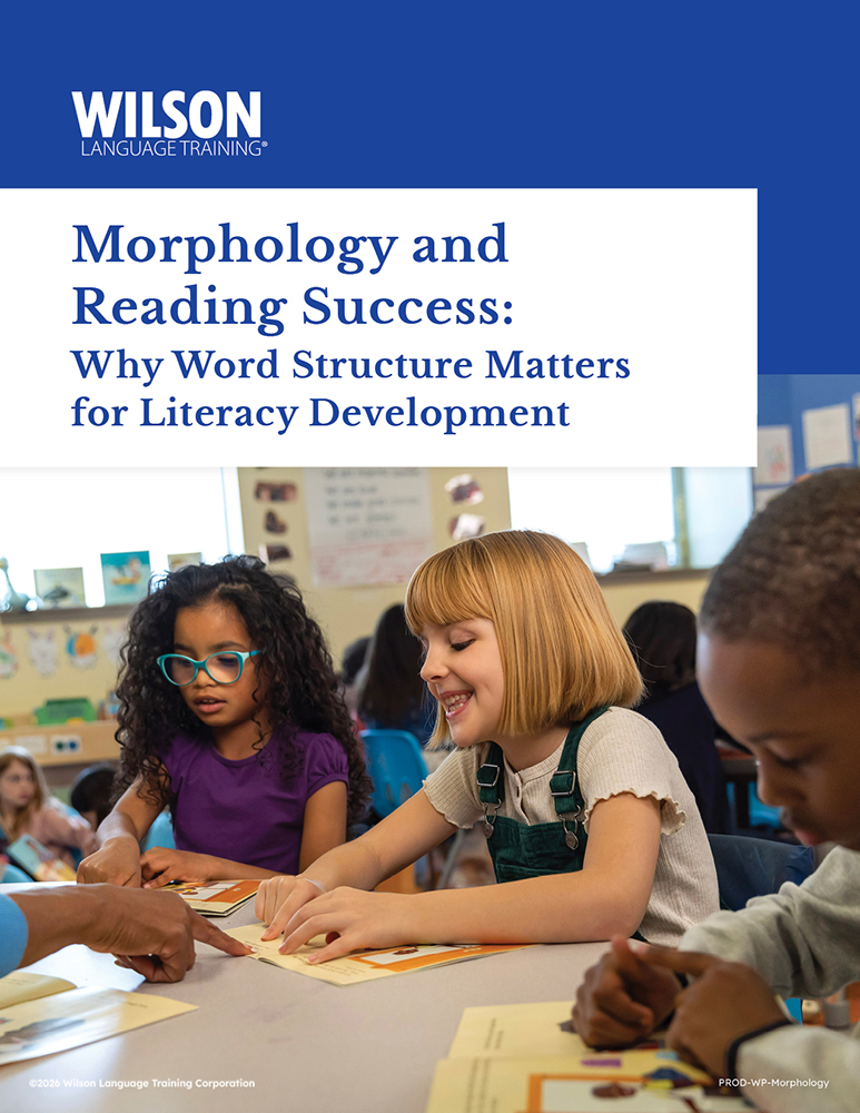 Children with open books and their teacher pointing to the page.